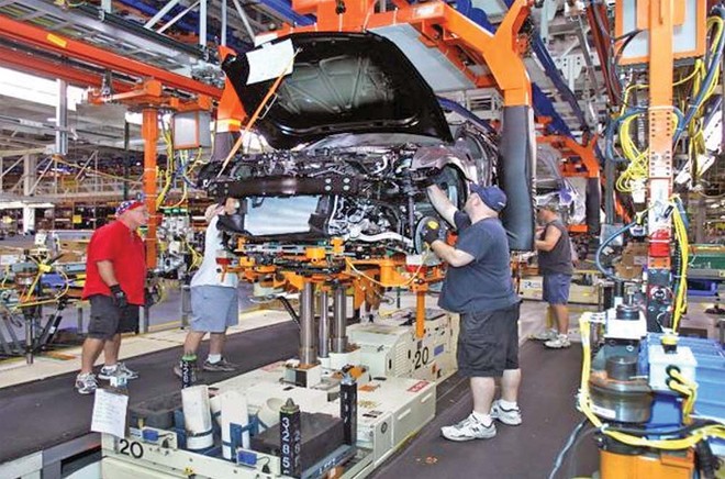 Công nhân làm việc trong dây chuyền lắp ráp ô tô của General Motors (bang Michigan, Mỹ). Ảnh: AFP