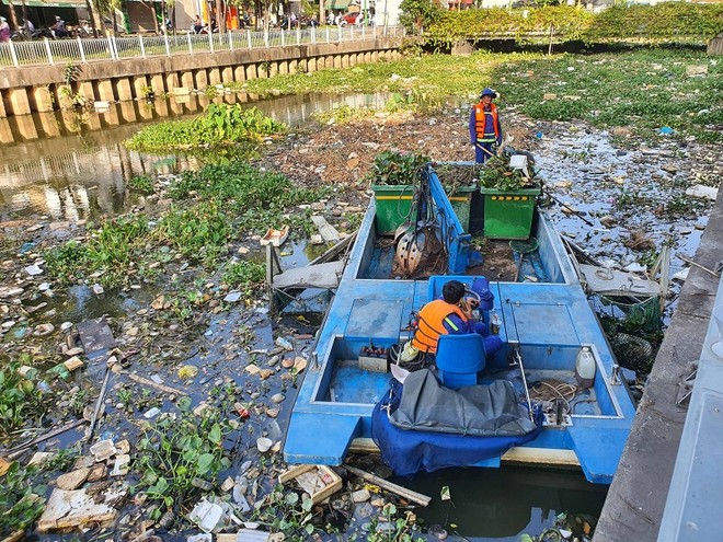 Công nhân môi trường vớt rác trên kênh Nhiêu Lộc - Thị Nghè. Dự án cũng được đầu tư bằng vốn vay Ngân hàng Thế giới - Ảnh: Lê Toàn 