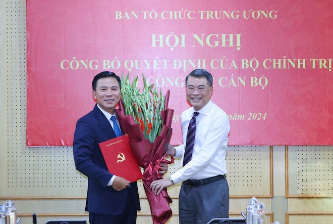 Trưởng ban Tổ chức Trung ương Lê Minh Hưng trao quyết định của Bộ Chính trị, tặng hoa chúc mừng ông Đỗ Trọng Hưng. Ảnh: TTXVN