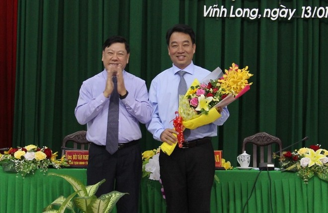 Ông Trần Văn Rón, Ủy viên Trung ương Đảng, Bí thư Tỉnh ủy Vĩnh Long (bên trái) tặng hoa chúc mừng tân Chủ tịch UBND tỉnh Vĩnh Long Lữ Quang Ngời.