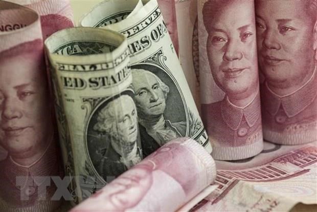 Đồng nhân dân tệ và đồng USD tại một ngân hàng ở Bắc Kinh, Trung Quốc. (Ảnh: AFP/TTXVN).