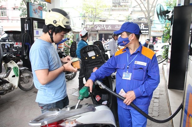 Nhân viên Petrolimex đang bán xăng cho khách hàng. (Ảnh: Đức Duy/Vietnam+).