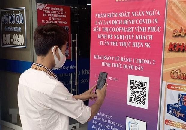 Người dân thực hiện quét mã QR khai báo y tế. (Ảnh: Hoàng Hùng/TTXVN)