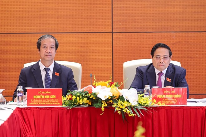 Thủ tướng Phạm Minh Chính và Bộ trưởng Bộ Giáo dục và Đào tạo Nguyễn Kim Sơn thảo luận tại tổ về các văn kiện Đại hội và dự thảo các văn kiện trình Đại hội XIV của Đảng - Ảnh: VGP/Nhật Bắc