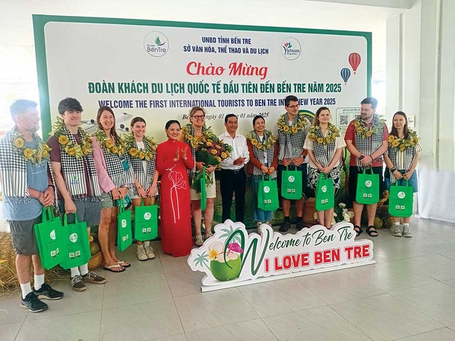 Bà Nguyễn Thị Ngọc Dung, Phó giám đốc Sở VHTTDL tỉnh Bến Tre (áo đỏ) và ngành du lịch chào mừng Đoàn khách du lịch quốc tế đầu tiên đến Bến Tre năm 2025