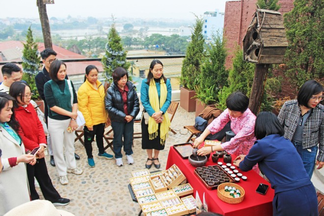 Đại biểu trải nghiệm tour “Đánh thức” tại xã Vân Đình, nghe giới thiệu về trà Trấn Thị. Ảnh: TITC