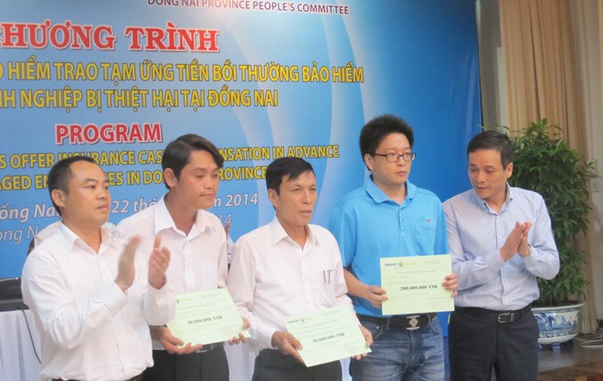 Ông Nguyễn Quang Phi - Phó Tổng Giám đốc Bảo hiểm Bảo Việt trao tiền bồi thường cho các doanh nghiệp tại Đồng Nai