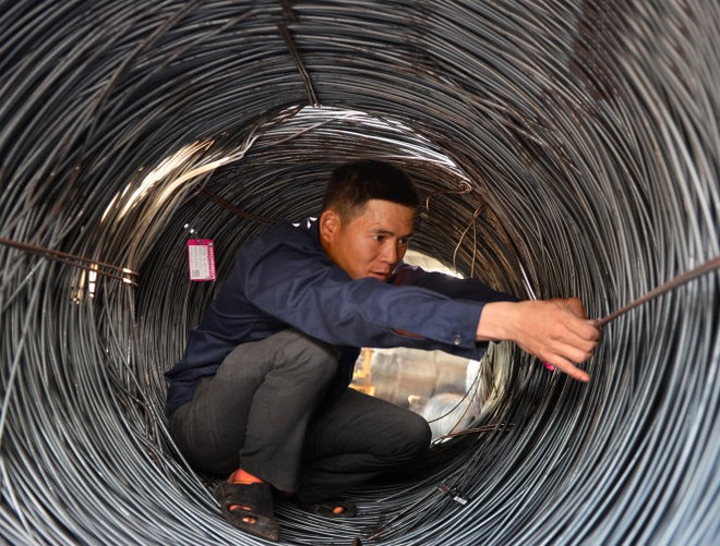 Ngày 16-3, giá thép cuộn bán ra 11,8 triệu đồng/tấn vào đầu giờ sáng, lên 12 triệu đồng/tấn vào buổi trưa và lên 12,5 triệu đồng/tấn vào đầu giờ chiều. Trong ảnh: nhân viên một cửa hàng thép ở TP.HCM treo nhãn hàng phân loại thép cuộn - Ảnh: Ảnh: H.Khoa