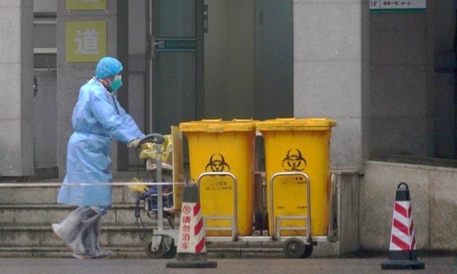 Công nhân thu gom rác thải y tế tại một trung tâm điều trị bệnh nhân nhiễm Covid-19 ở Vũ Hán hôm 22/1. Ảnh: 
AP.