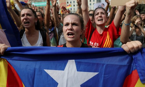 Một phụ nữ cầm cờ ly khai của Catalonia trên đường phố Barcelona hôm 2/10. Ảnh:Reuters.