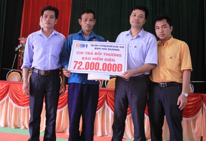 Ông Đỗ Văn Hải – Phó tổng giám đốc BSH trao bồi thường cho anh Nguyễn Bá Hữu
