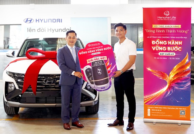 Khách hàng Nguyễn Quốc Đạt (bên phải) nhận giải Đặc biệt ô tô Hyundai Tucson từ chương trình khuyến mại “Đồng Hành Vững Bước” của Hanwha Life Việt Nam