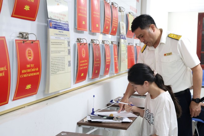Công chức thuế hướng dẫn người dân làm thủ tục kê khai thuế. Ảnh: Dũng Minh