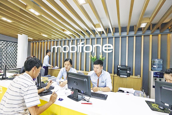 Cần có quy định rõ ràng hơn về cơ chế, chính sách để doanh nghiệp nhà nước dám đột phá, dám đổi mới. Trong ảnh: Nhân viên Mobifone hỗ trợ khách hàng tại quầy giao dịch. Ảnh: Đức Thanh 