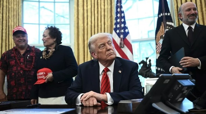 Tổng thống Mỹ Donald Trump và Bộ trưởng Thương mại Howard Lutnick (phải) tại buổi ký tuyên bố mở rộng quyền đánh bắt tại các đảo Thái Bình Dương, diễn ra ở Phòng Bầu dục của Nhà Trắng vào ngày 17/4/2025. Ảnh: AFP