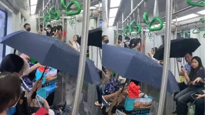 Hành khách che ô khi đi tàu metro Cát Linh - Hà Đông.