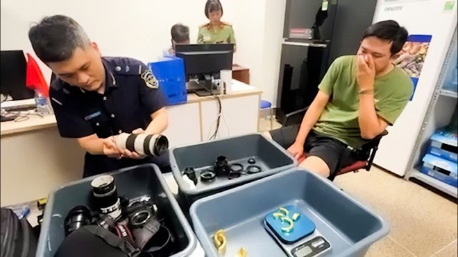 Đối tượng (bên phải) tại cơ quan chức năng.