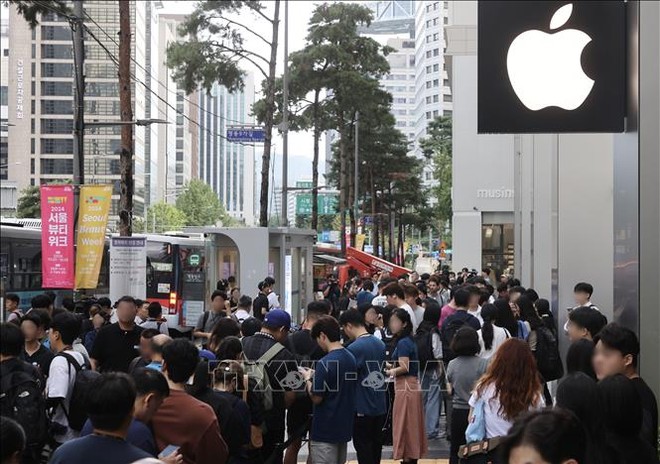 Khách hàng chờ đợi bên ngoài một cửa hàng của Apple tại Seoul, Hàn Quốc. Ảnh: Yonhap/TTXVN