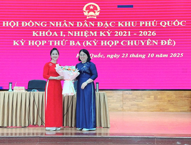 Bà Đặng Thị Hồng Gấm, Phó Bí thư Thường trực Đảng ủy, Chủ tịch HĐND đặc khu Phú Quốc (bên phải) tặng hoa chúc mừng bà Nguyễn Thị Kim Loan.