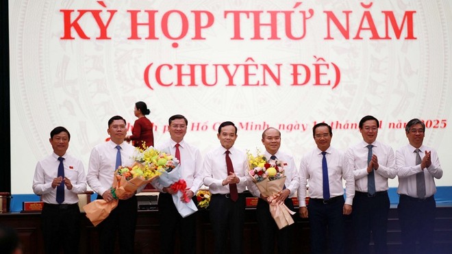 Bí thư Thành ủy TP.HCM Trần Lưu Quang tặng hoa chúc mừng 3 tân Phó chủ tịch UBND TP.HCM - Ảnh: H.K