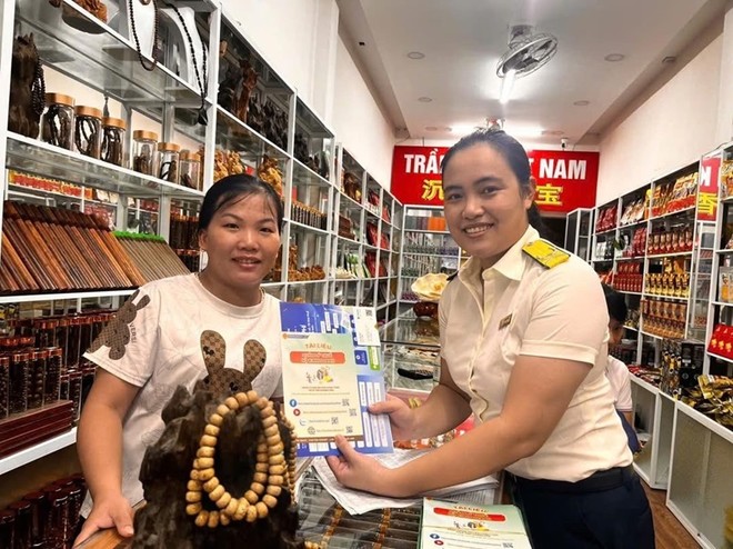 Công chức thuế tuyên truyền, giới thiệu ứng dụng thuế điện tử đến người nộp thuế. Ảnh: TN