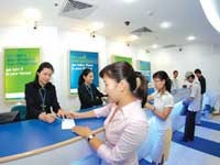 Nhân viên NH Standard Chartered hướng dẫn khách hàng thực hiện giao dịch.