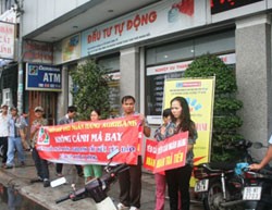 Các khách hàng là nạn nhân của vụ án "lừa đảo, chiếm đoạt tài sản" căng băng rôn trước trụ sở chi nhánh ngân hàng sáng 22/9
