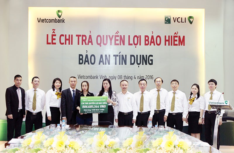 Bà Lê Thị Huệ Anh - Giám đốc Vietcombank Vinh (thứ 7 từ phải sang) trao quyền lợi bảo hiểm nhân thọ Bảo an Tín dụng cho người thụ hưởng Trần Thị Mai Phương (Ảnh: Nguyễn Văn Thắng)