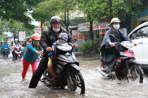 Một gia đình TP HCM đưa con đi học trong cơn mưa ở TP HCM. Ảnh minh họa: Mạnh Tùng.