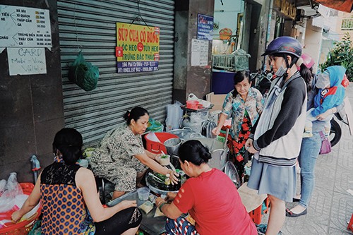 Khách đứng trước nồi súp chờ mua mang về. Ảnh: Di Vỹ.