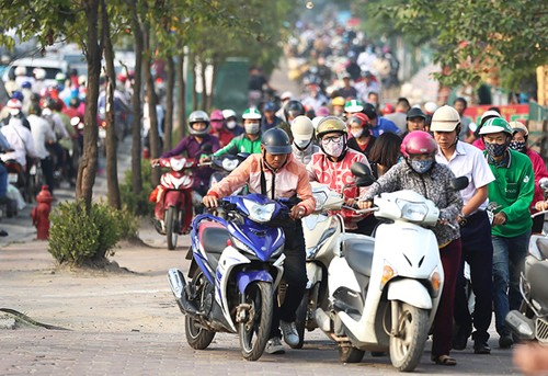 Bị cấm đường, người dân leo lên vỉa hè đường Lê Văn Lươngđi ngược chiều. Ảnh:Ngọc Thành.