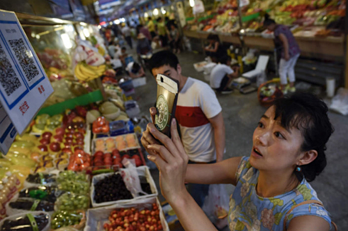 Một khách hàng Trung Quốc đang quét mã QR để thanh toán. Ảnh: VCG.