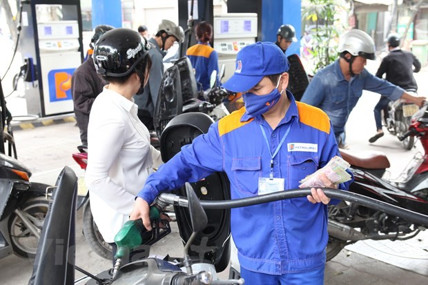 Nhân viên Petrolimex đang bán xăng cho khách hàng. (Ảnh: Đức Duy/Vietnam+).