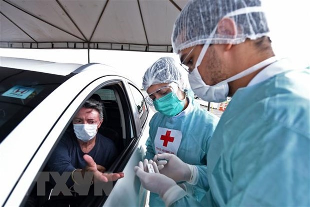 Nhân viên y tế xét nghiệm nhanh COVID-19 cho người dân tại Brasilia, Brazil. (Ảnh: AFP/TTXVN)