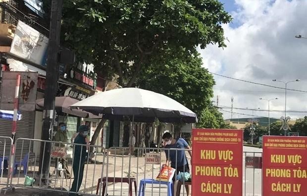 Người dân trong khu vực phong tỏa trên phố Ngô Quyền (Hải Dương) nhận thực phẩm tiếp tế tại hàng rào cách ly. (Ảnh: Mạnh Minh/TTXVN).