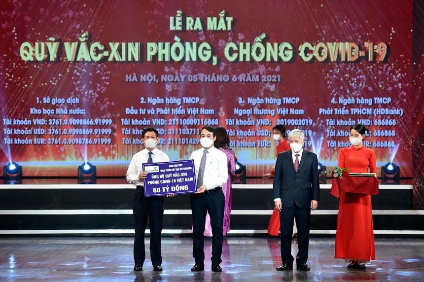 Ông Nghiêm Xuân Thành - Uỷ viên BCH Trung ương Đảng, Ủy viên BTV Đảng ủy khối DNTW, Bí thư Đảng ủy, Chủ tịch HĐQT Vietcombank (thứ 2 từ trái sang) trao biển ủng hộ 60 tỷ đồng cho Quỹ vắc-xin phòng, chống COVID-19.