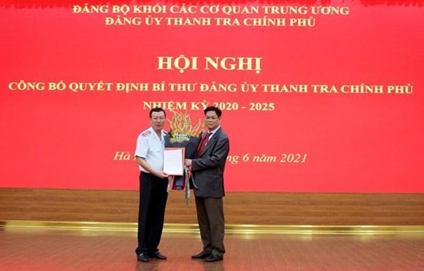 Bí thư Đảng ủy Khối các cơ quan Trung ương Huỳnh Tấn Việt trao quyết định và tặng hoa tân Bí thư Đảng ủy Thanh tra Chính phủ Đoàn Hồng Phong (trái). (Nguồn: thanhtra.com.vn).