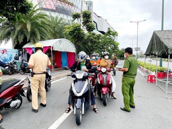 Lực lượng Công an tại chốt kiểm trên đường Phạm Văn Đồng, phường Hiệp Bình Chánh, Thủ Đức, kiểm tra giấy tờ của người lưu thông. (Ảnh: Thành Chung/TTXVN).