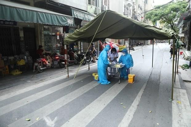 Nhân viên y tế quận Hoàn Kiếm lấy mẫu xét nghiệm COVID-19 cho các trường hợp có nguy cơ cao. (Ảnh: TTXVN).