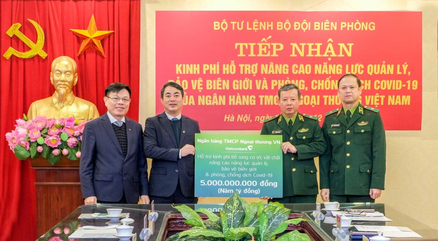 Ông Nghiêm Xuân Thành - Bí thư Đảng ủy, Chủ tịch HĐQT Vietcombank (thứ 2 bên trái) và ông Đào Minh Tuấn, Phó tổng giám đốc, Chủ tịch Công đoàn Vietcombank (ngoài cùng bên trái) trao biển tượng trưng số tiền 5 tỷ đồng Vietcombank ủng hộ cho đại diện Bộ Tư lệnh Bộ đội biên phòng: Thiếu tướng Nguyễn Đức Mạnh, Phó Tư lệnh Bộ đội biên phòng (thứ 2 bên phải) và Thiếu tướng Nguyễn Anh Tuấn, Chủ nhiệm Chính trị Bộ đội biên phòng