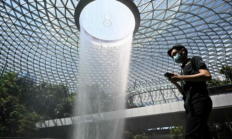 Hành khách di chuyển qua khu vực thác nước Rain Vortex tại sân bay Jewel Changi, Singapore ngày 27/2/2020. Ảnh tư liệu: AFP