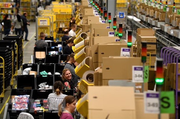 Nhân viên đóng gói hàng hóa cho khách hàng tại trung tâm dịch vụ của Amazon. (Ảnh: AFP/TTXVN)