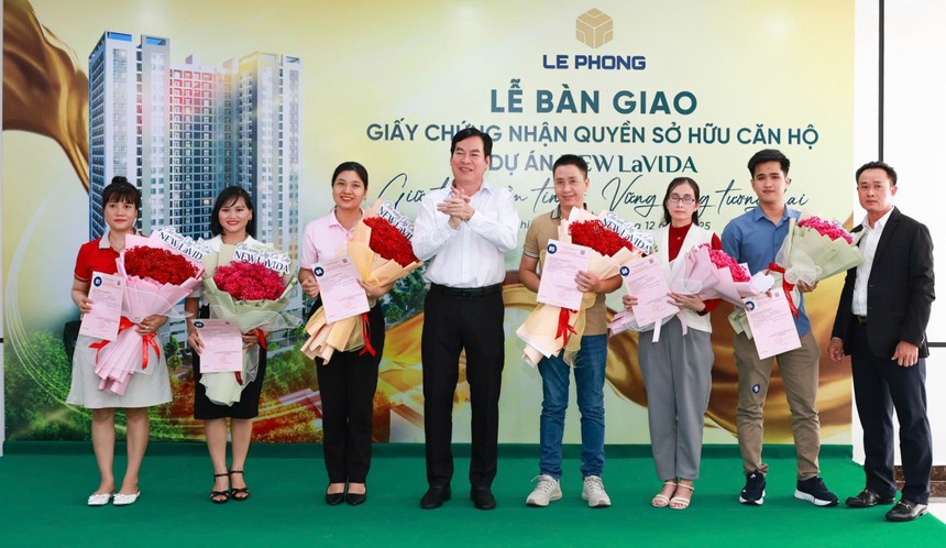 Đại diện Tập đoàn Lê Phong trao giấy chứng nhận quyền sở hữu căn hộ và hoa cho cư dân.