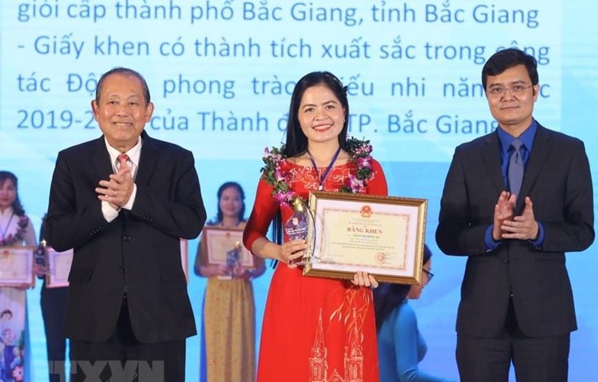 Phó Thủ tướng Thường trực Trương Hòa Bình (bên trái) và Bí thư Trung ương Đoàn, Chủ tịch Trung ương Hội Sinh viên Việt Nam Bùi Quang Huy trao Bằng khen và biểu trưng, tuyên dương 'Nhà giáo trẻ tiêu biểu' cấp Trung ương lần thứ II.(Ảnh: Văn Điệp/TTXVN).