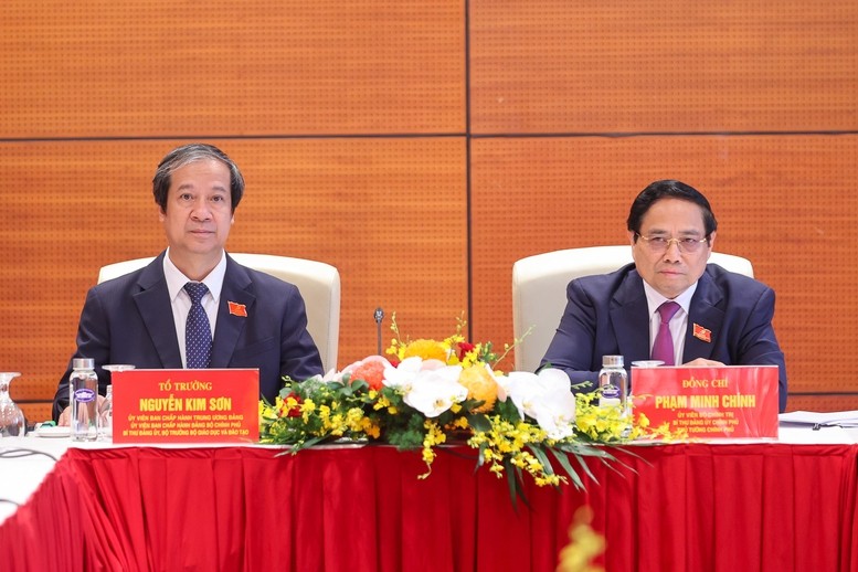Thủ tướng Phạm Minh Chính và Bộ trưởng Bộ Giáo dục và Đào tạo Nguyễn Kim Sơn thảo luận tại tổ về các văn kiện Đại hội và dự thảo các văn kiện trình Đại hội XIV của Đảng - Ảnh: VGP/Nhật Bắc