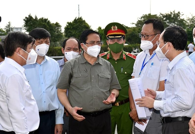 Thủ tướng Phạm Minh Chính nghe lực lượng chức năng báo cáo việc thực hiện Chỉ thị 16 tại phường Tân Phú, TP. Thủ Đức, TPHCM, ngày 11/7 (Ảnh: VGP)