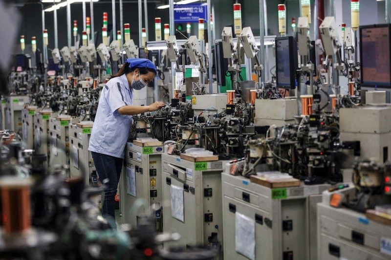 Công nhân làm việc tại dây chuyền sản xuất cuộn cảm của một nhà máy ở thành phố Tô Thiên, tỉnh Giang Tô, Trung Quốc. Ảnh: AFP