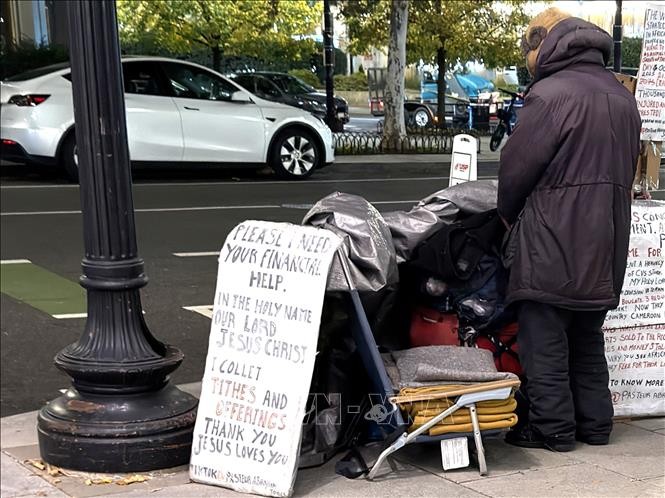 Một người vô gia cư với tấm biển cần giúp đỡ về tài chính trên một tuyến phố ở trung tâm thủ đô Washington D.C. 
