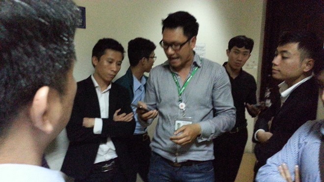 Nhóm người xưng nhân viên VPBank đứng chắn cửa căn hộ 1401 nhà 17T2.
(Cầu Giấy, Hà Nội) - Ảnh: Lao động