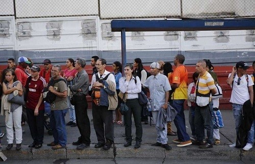 Người dân chờ xe buýt ở Caracas. Ảnh: AP.